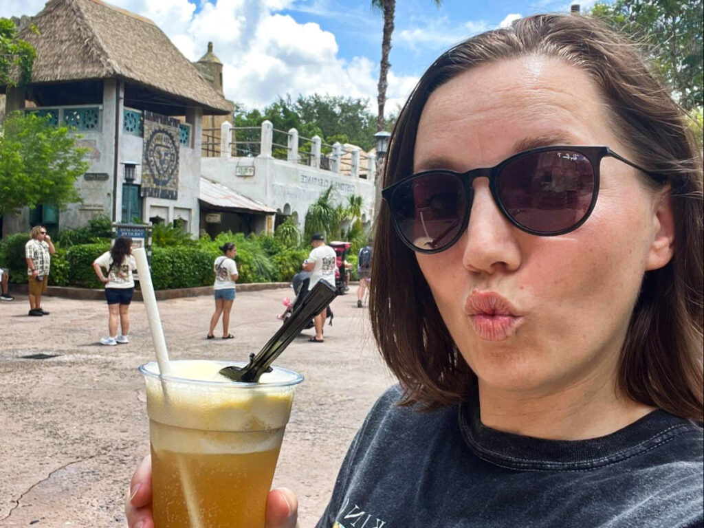 The author Katie holding a cup of spiked Dole Whip float