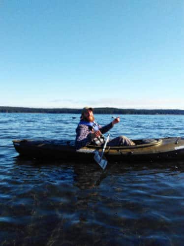 A man smiling for a photo while on his kayak