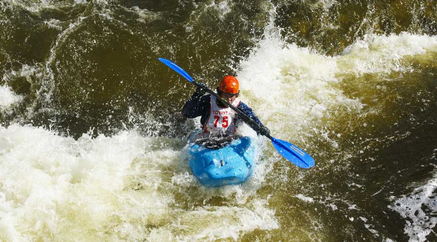 A man enjoying kayaking through the rapid water in Frisco, Colorado
