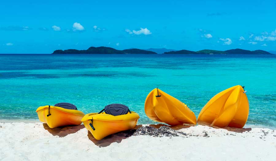 Four yellow kayaks at the shoreline of Great Cruz Bay