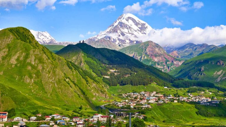 Aerial view of the village of Stepantsminda and the Gergeti Trinity Church with the Kazbegi Mountain in the background