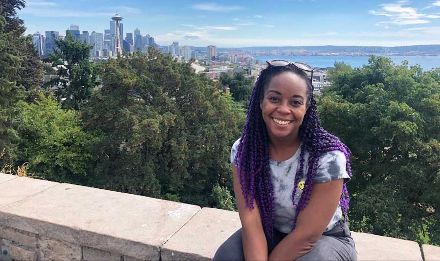The author smiling for a photo at Kerry Park with the overlooking view on her background