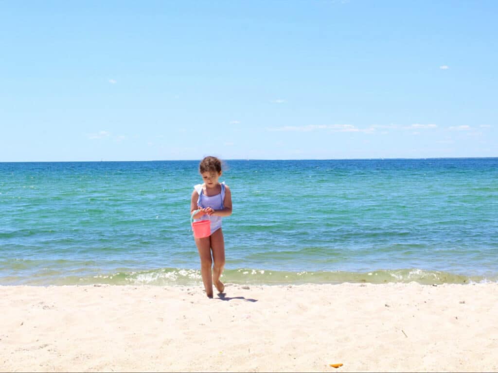 A child walking along the shoreline in Cape Cod beach