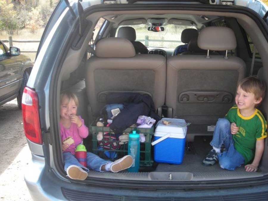 Little kids sitting at the back of the car after their hike