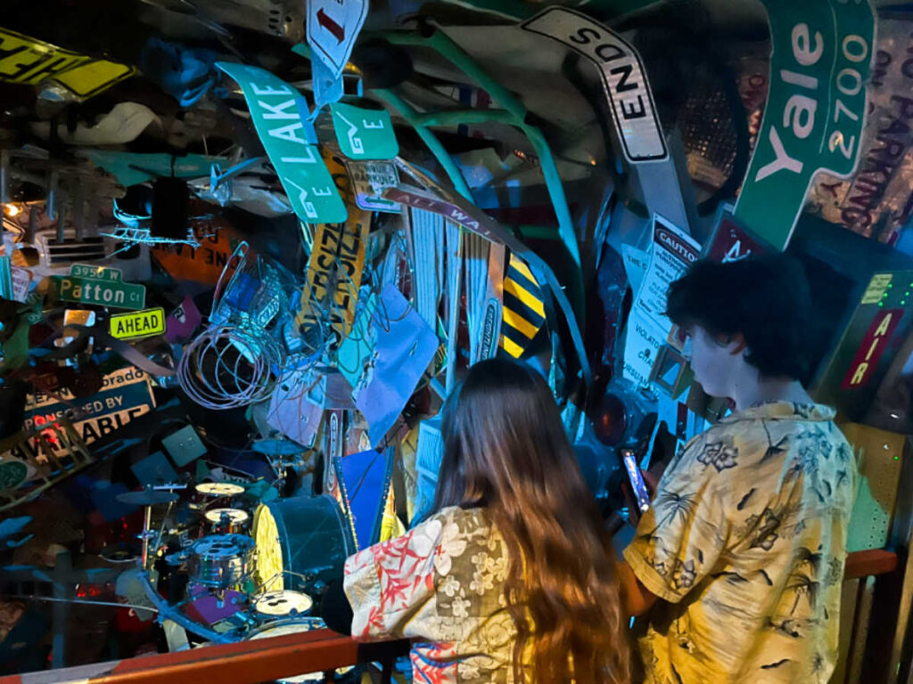 The kids looking at the scrap signages and plate numbers at the Meow Wolf