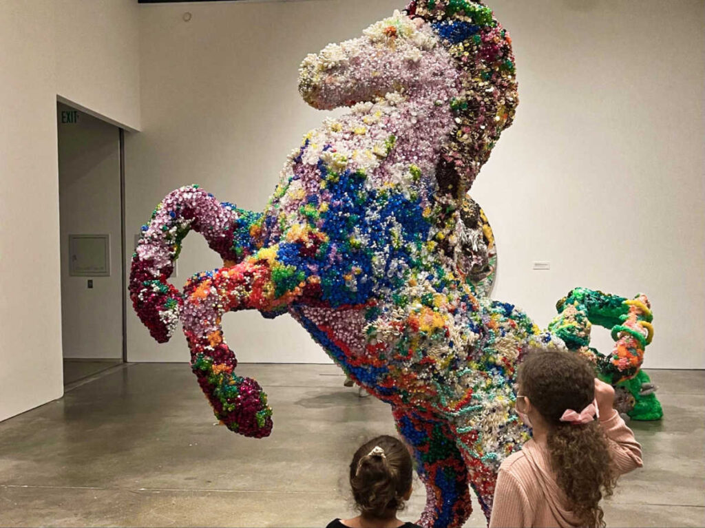 The children admiring the colorful horse sculpture