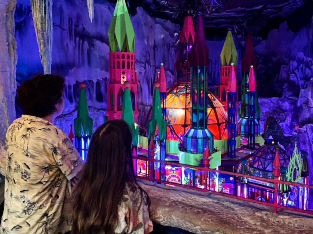 The kids overlooking the colorful art installation inside the Meow Wolf