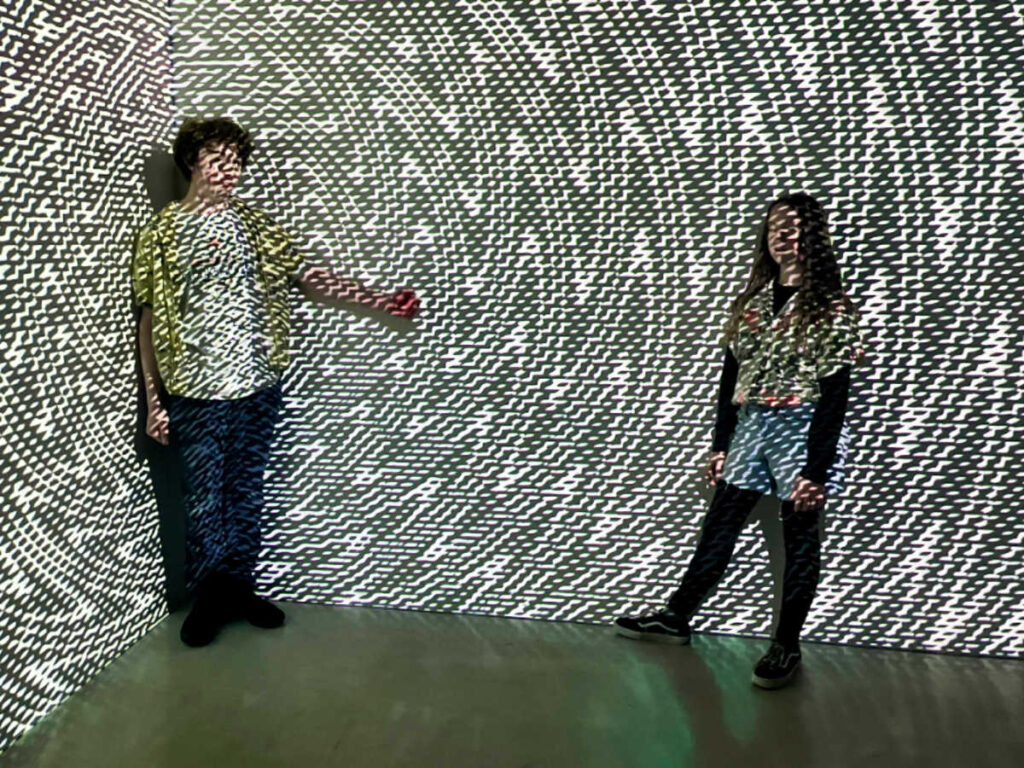 The kids enjoying under the immersive light in Meow Wolf