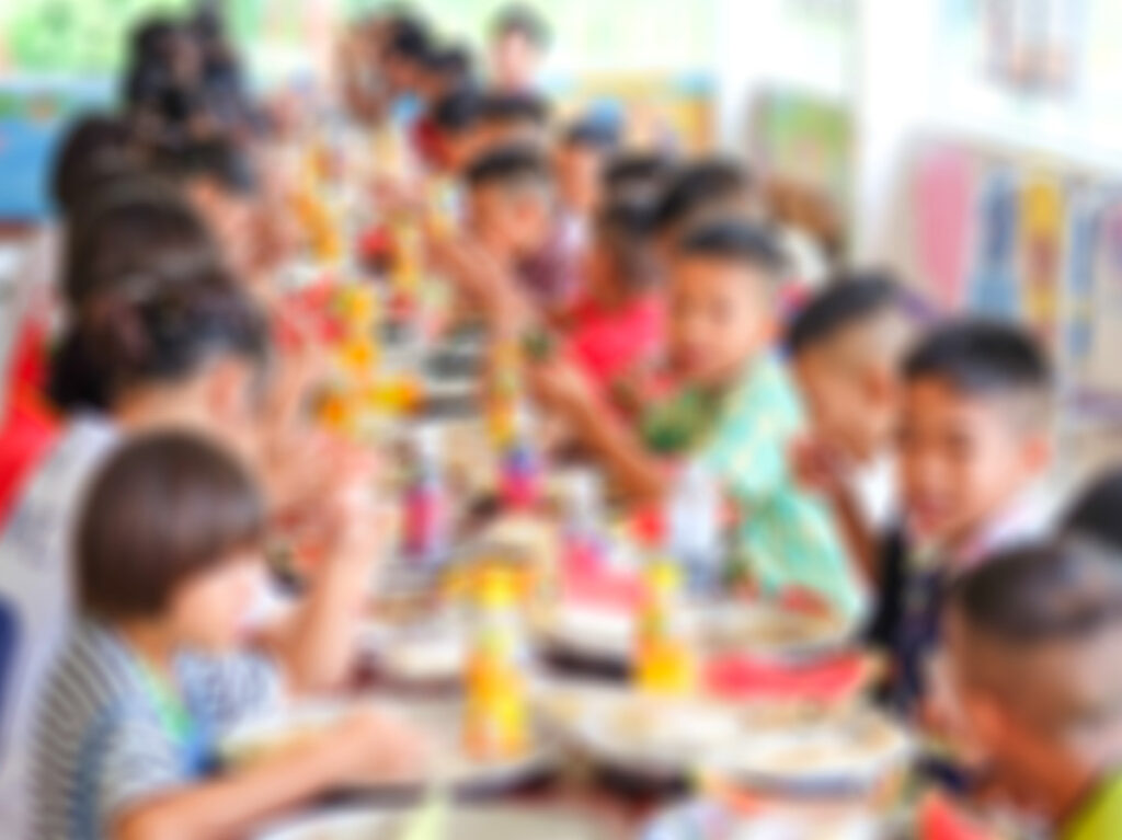 Blurred image of Thai kids eating lunch in a social school orphanage