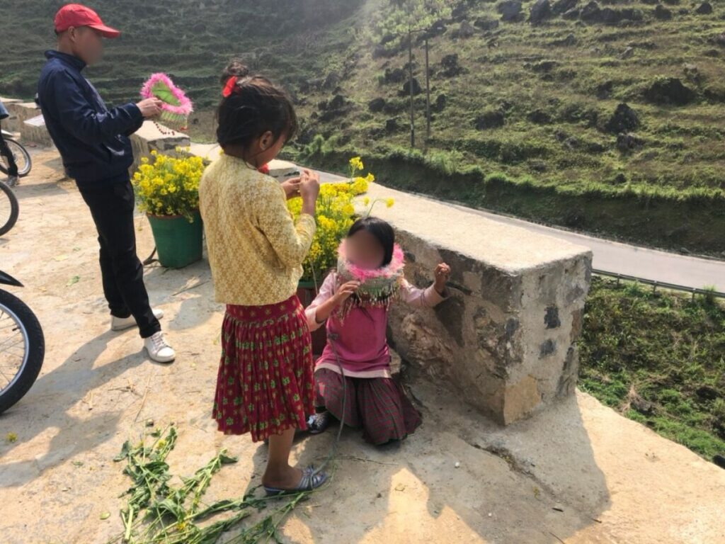Kids making flower crowns along the road