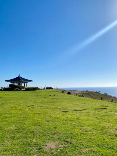 A grassy hill with a gazebo atop, showcasing the Korean Bell of Friendship Park
