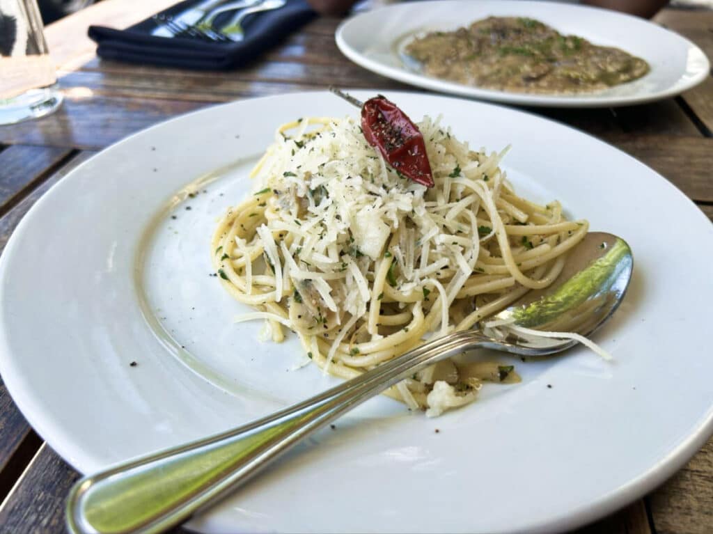 A plate of pasta topped with cheese and chili from La Bottega Cafe Deli