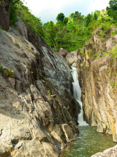 View of the cascading water of La Canoa Waterfall between the rocky mountains
