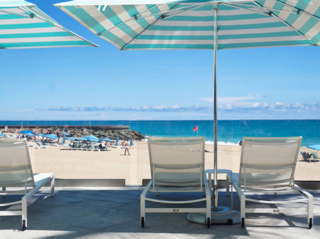 View of the lounge chairs under an umbrella facing the beach at La Concha Renaissance San Juan Resort