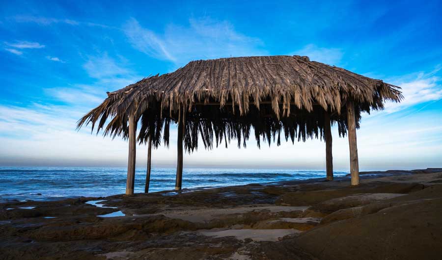 A palm leaf hut under the clear blue sky in Windansea Beach