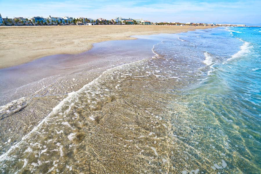 View of the clear water on the shore at La Malvarrosa Beach