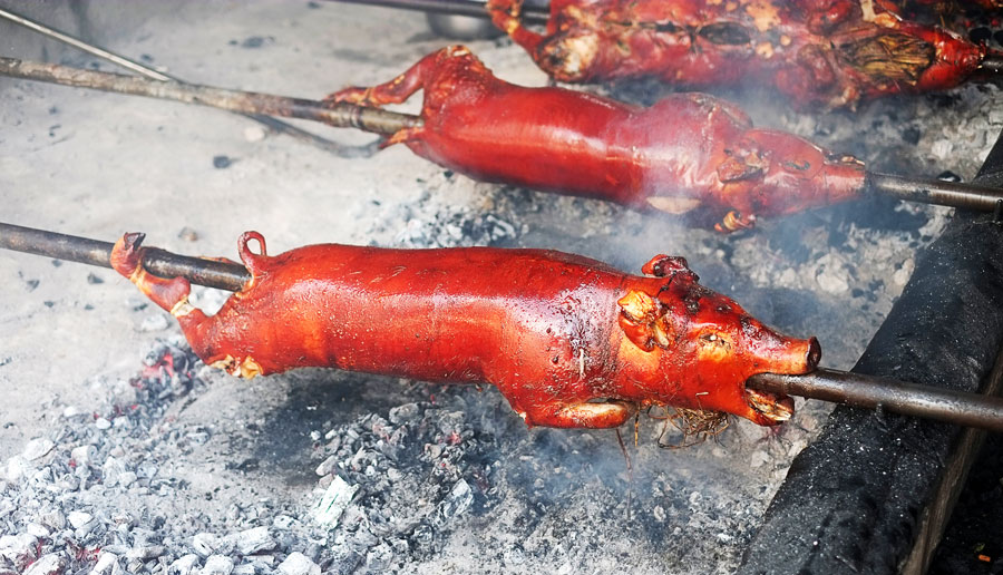 View of lechon being roasted in a charcoal