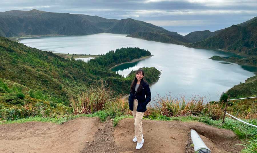 The author smiling for a photo with the Lagoa do Fogo on her background