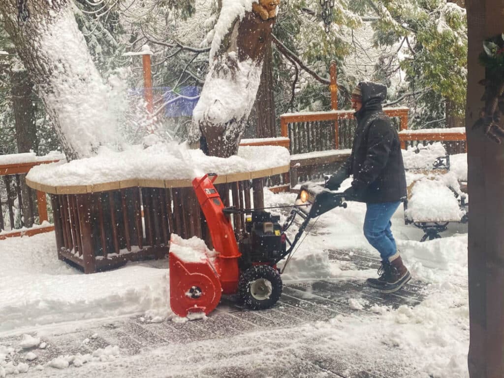 The author's dad blowing snow from a Lake Arrowhead cabin porch