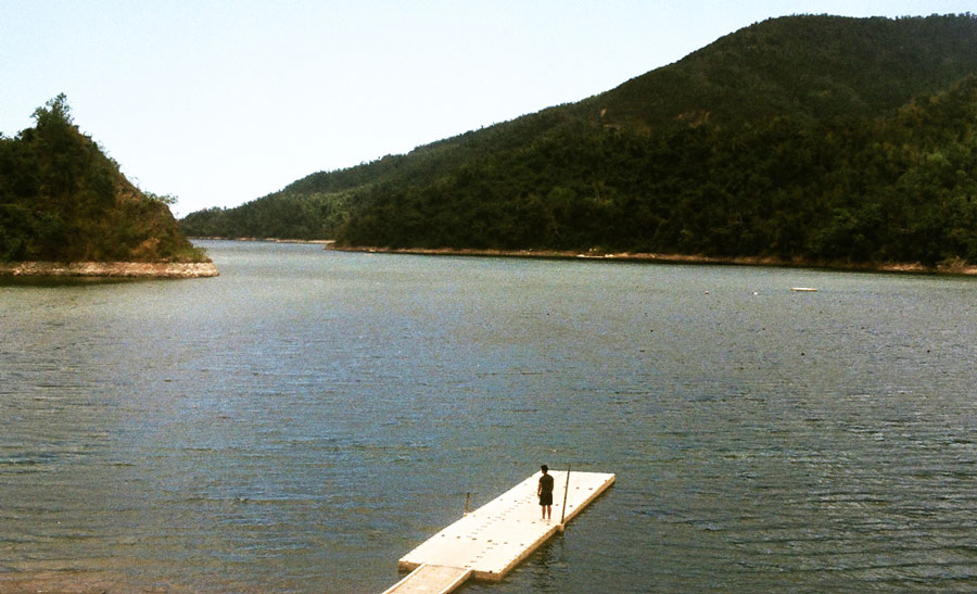 View of a man standing on a boardwalk in Lake Cerillos