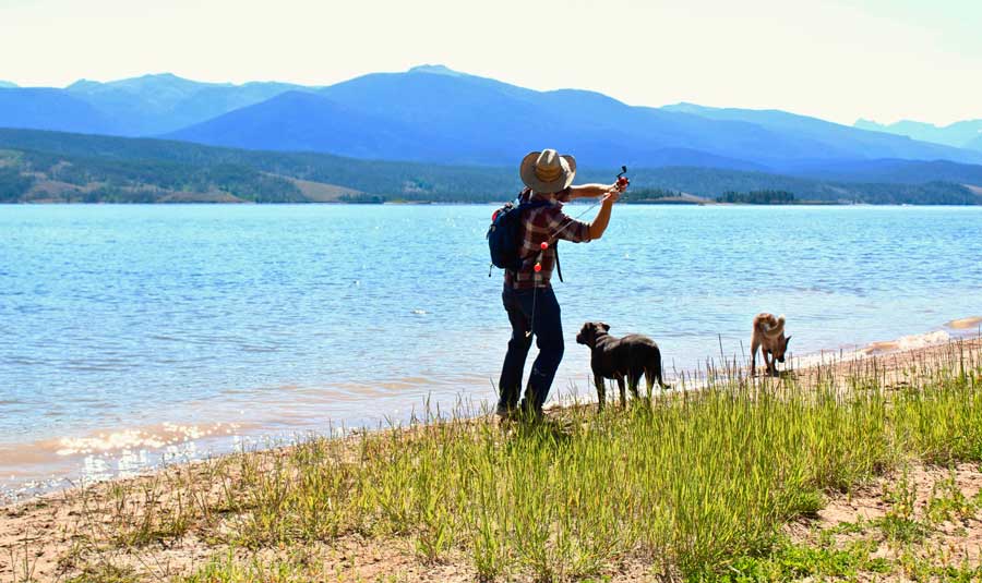 The author's husband fishing in Lake Granby with their dogs