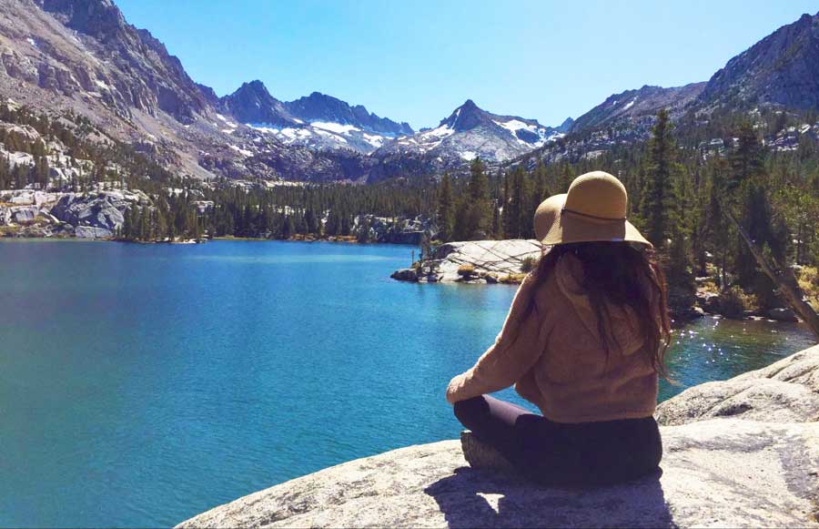 The author meditating with the view of Lake Sabrina in Bishop