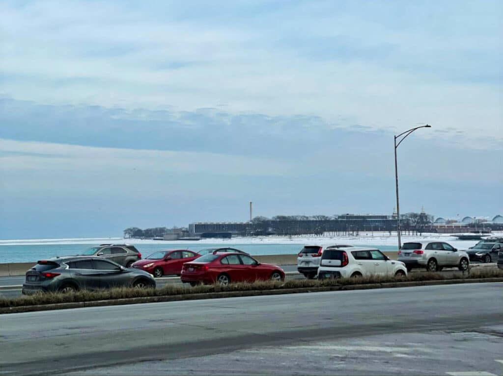 View of the cars driving with the Lake Shore view in winter