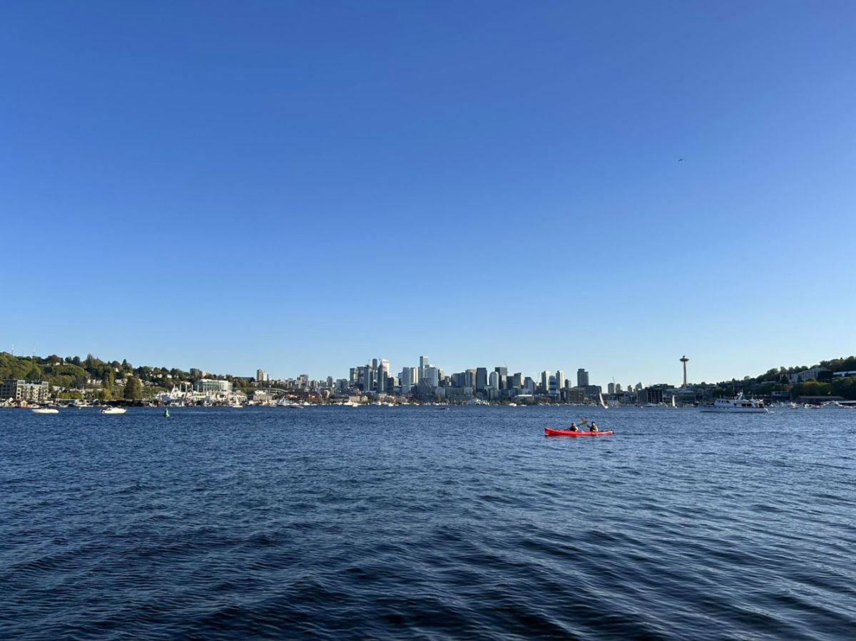 People kayaking on water with Seattle skyline in background