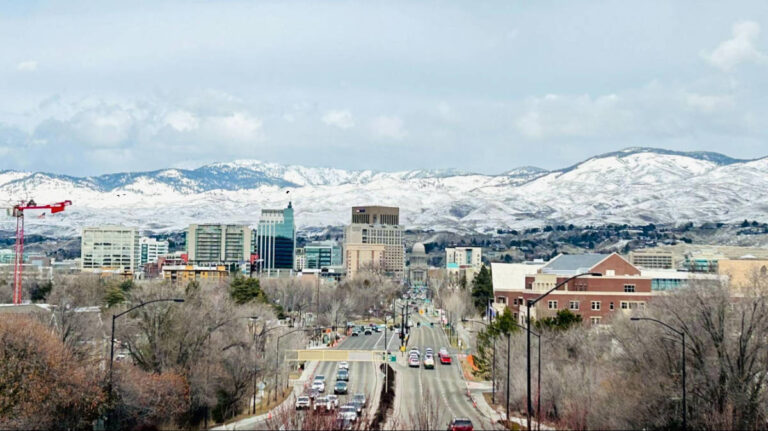 Panoramic view of the cityscape with snow covered mountain views in the background
