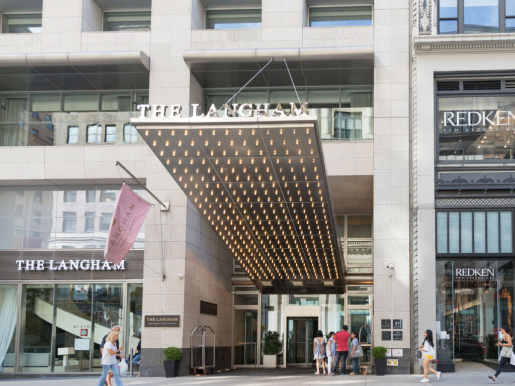 People walk by The Langham hotel in New York city