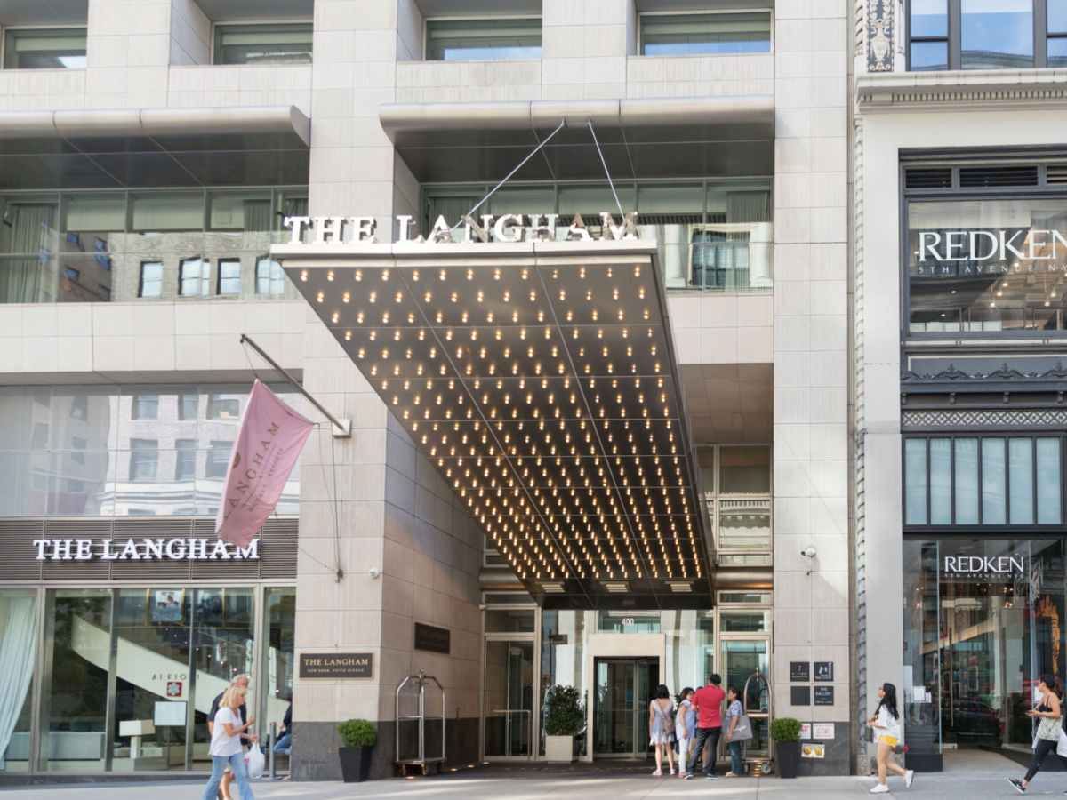 People walk by The Langham hotel in New York city