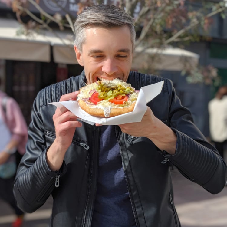 The author Nate Hake eating traditional langos on the street
