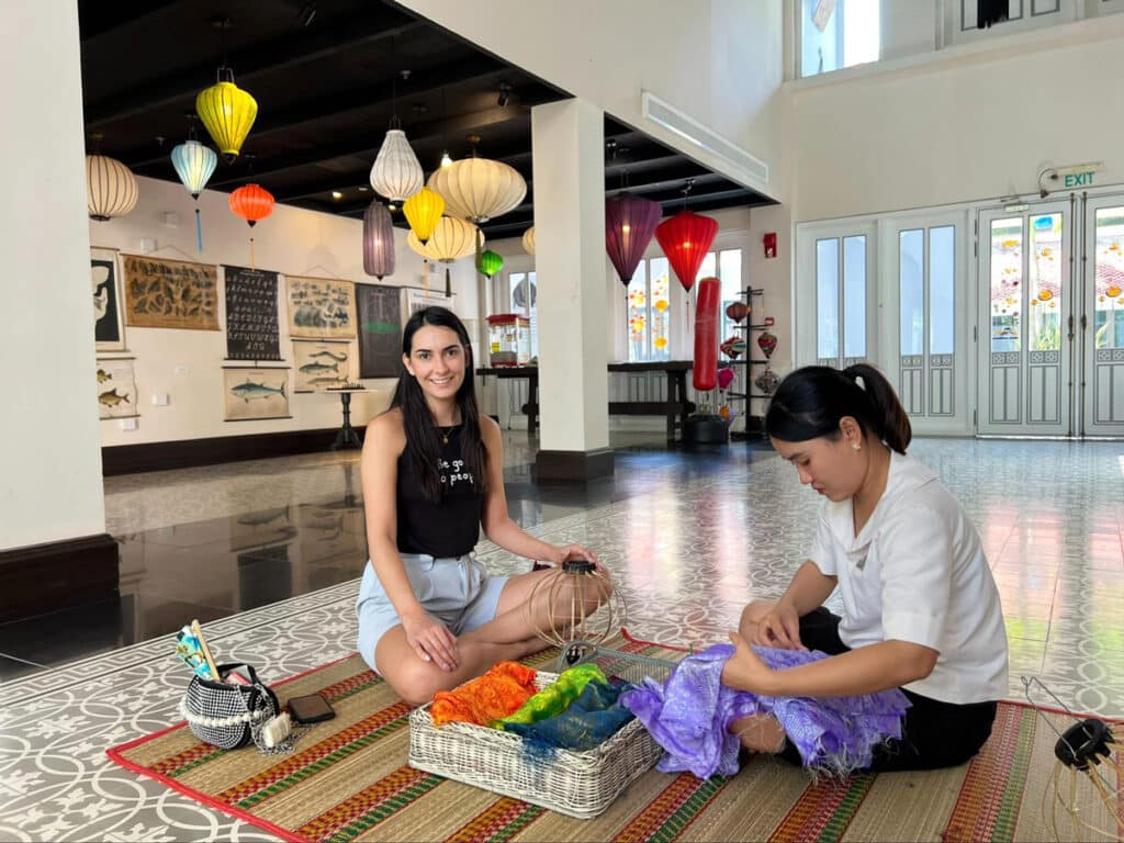 Clara smiling for a photo while making a lantern