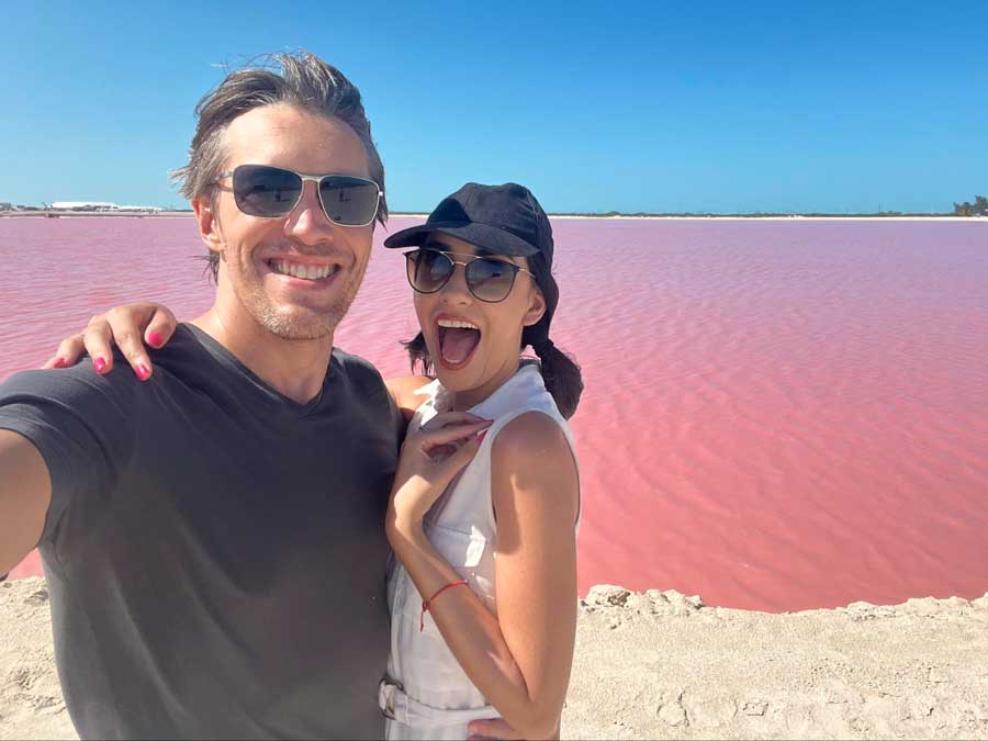 The author with his partner taking a photo and the Las Coloradas Pink Lake on their background