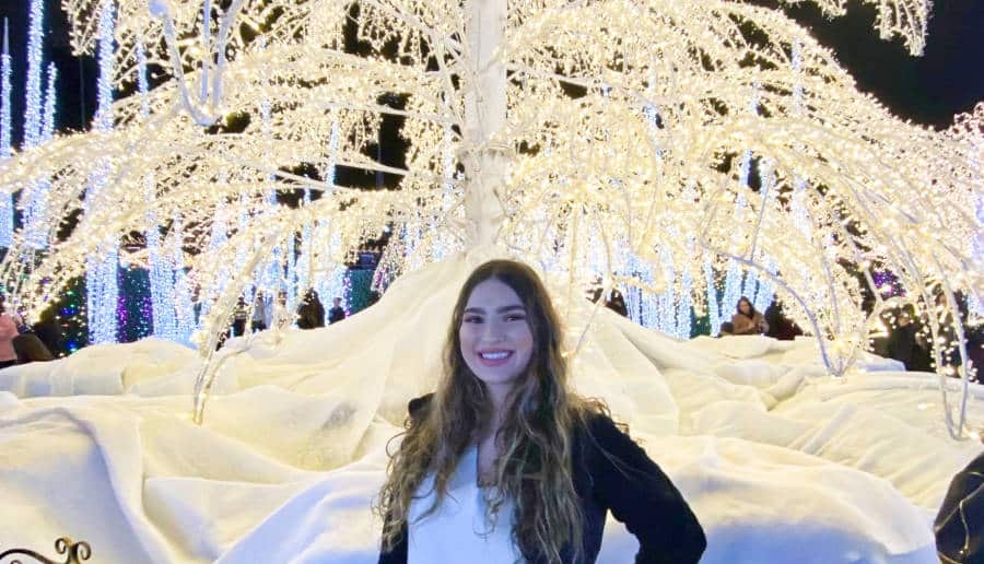 The author Isabelle Pavese posing near the illuminated white tree at Enchant Las Vegas Ballpark