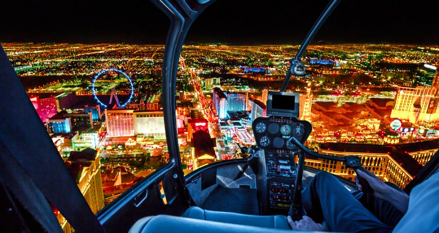 View of the scenic illuminated skyscrapers of downtown Las Vegas from the inside of a helicopter ride at night
