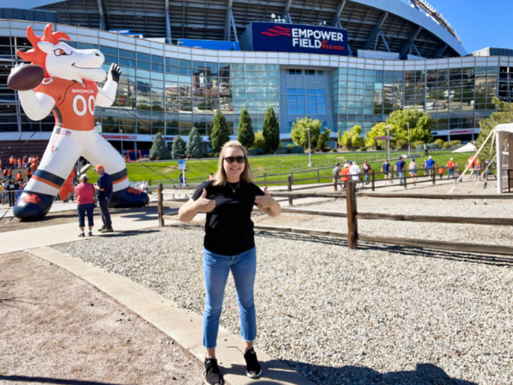 The author, Laura Falin, posing in front of the Empower Field