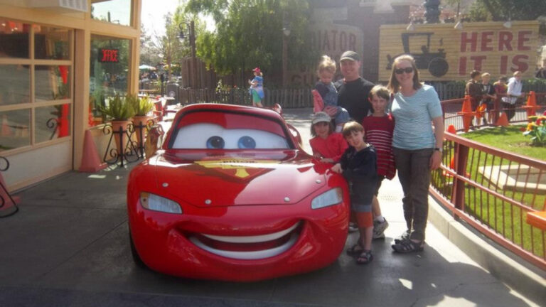 Laura Falin with her family, posing for a photo with Lightning McQueen