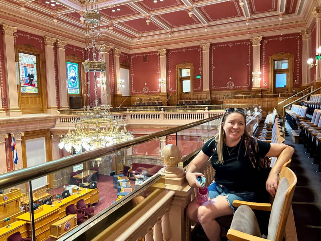 The author, Laura Falin smiling for a photo inside the Colorado State Capitol Building