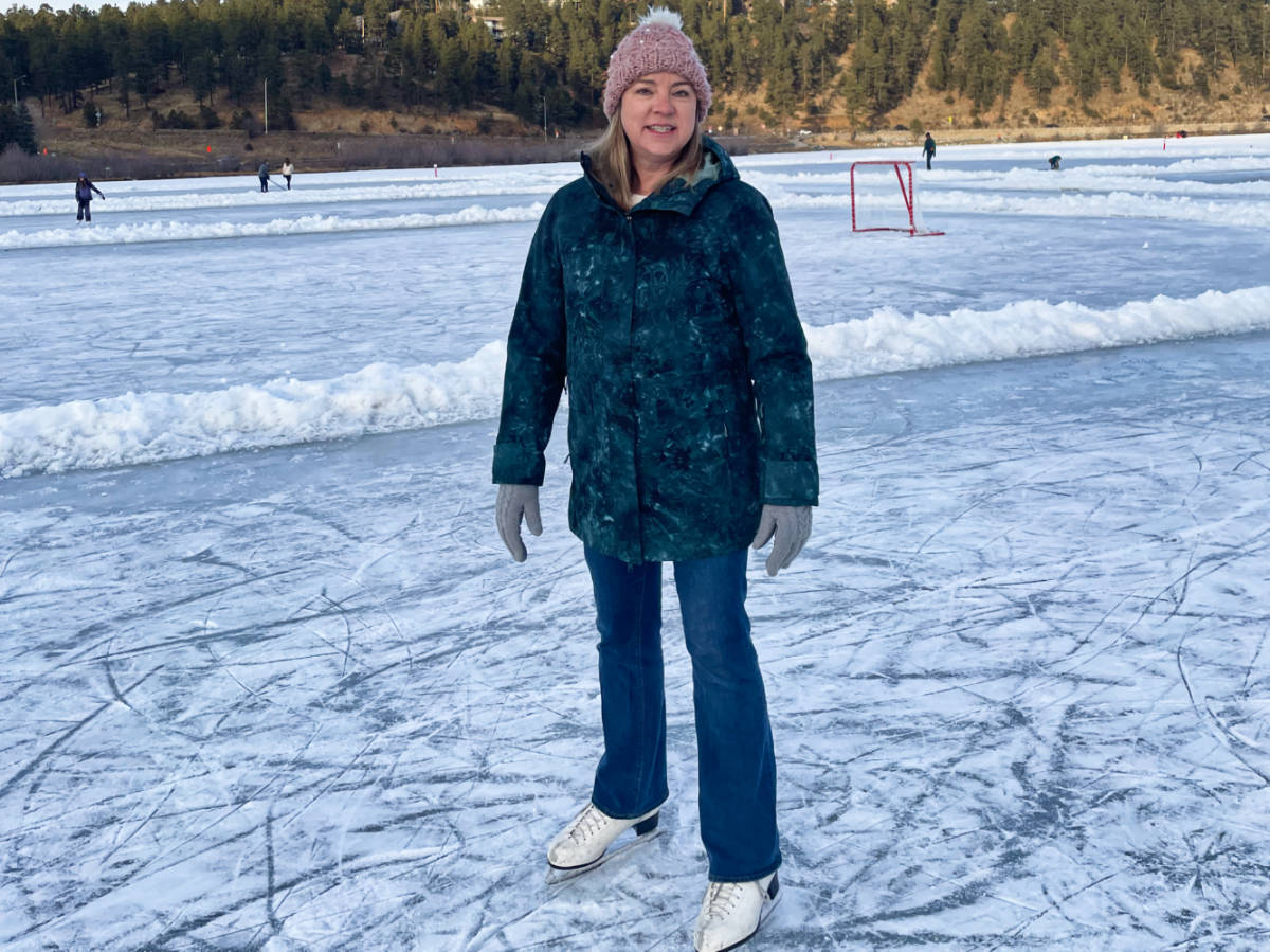 The author Laura Falin, standing with her skates on the Frozen Evergreen Lake