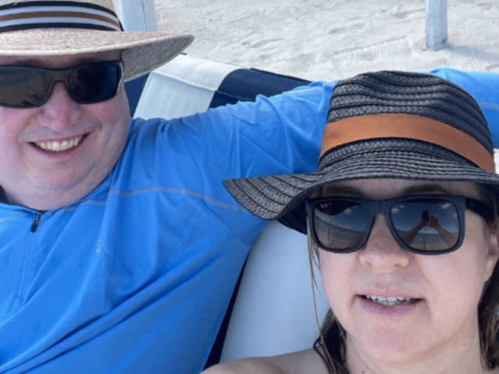 The author Laura Falin with her husband relaxing on a beach