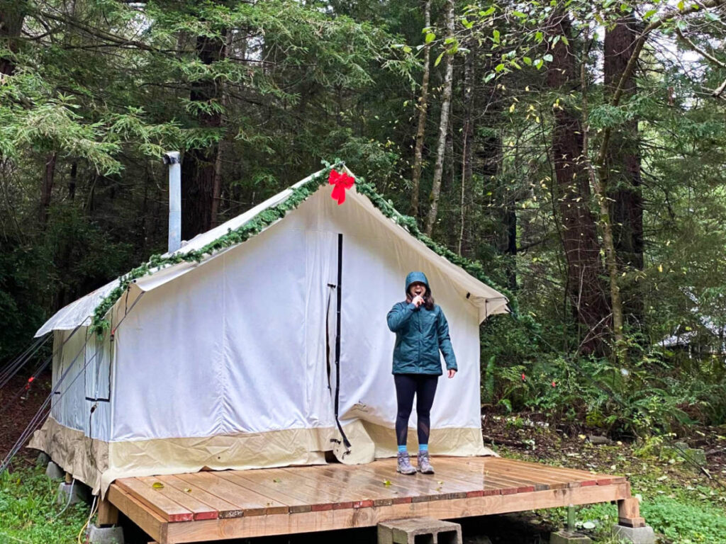 Travel Lemming Writer Laura McFarland, smiling for a photo outside her glamping tent in Trinidad