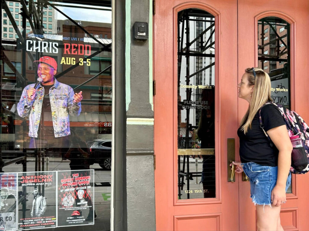 Travel Lemming writer, Laura Falin at the entrance of Comedy Works