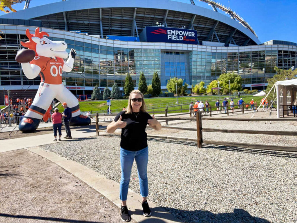 The author, Laura Falin, posing in front of the Empower Field