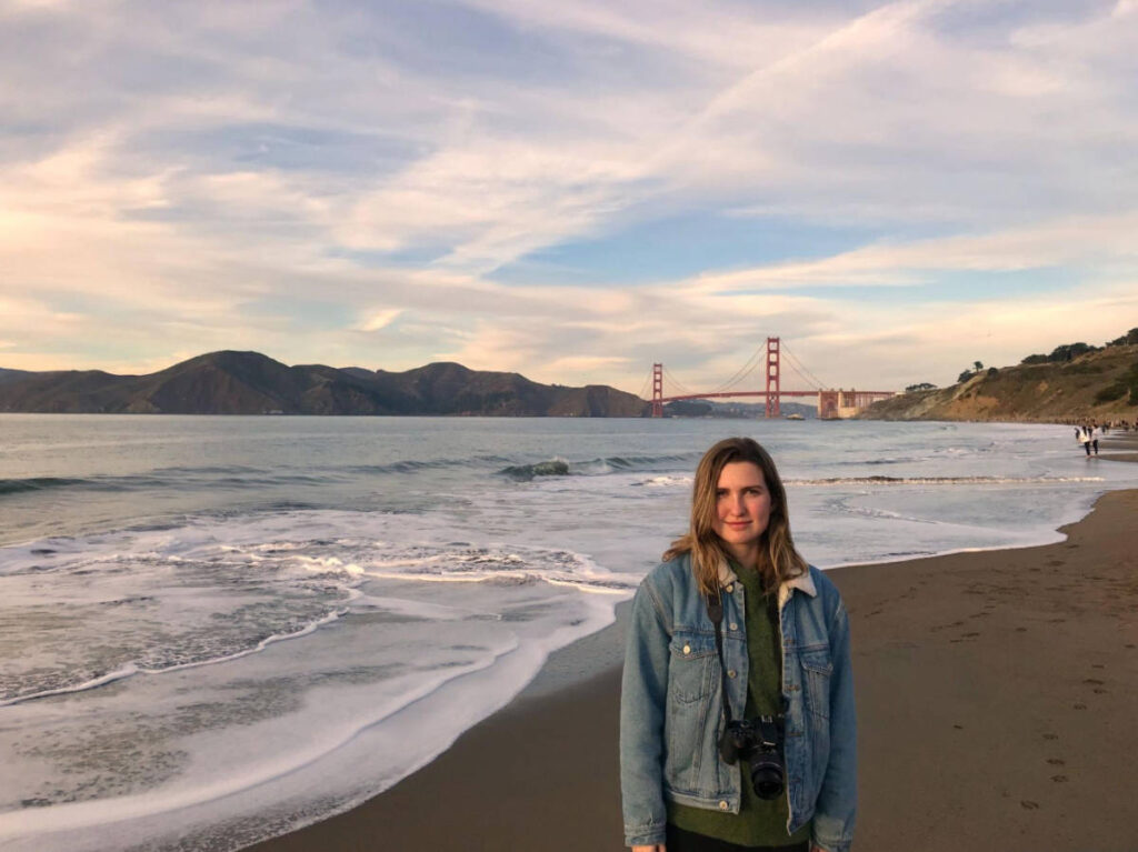 The author, Laura McFarland smiling for a photo at Baker Beach