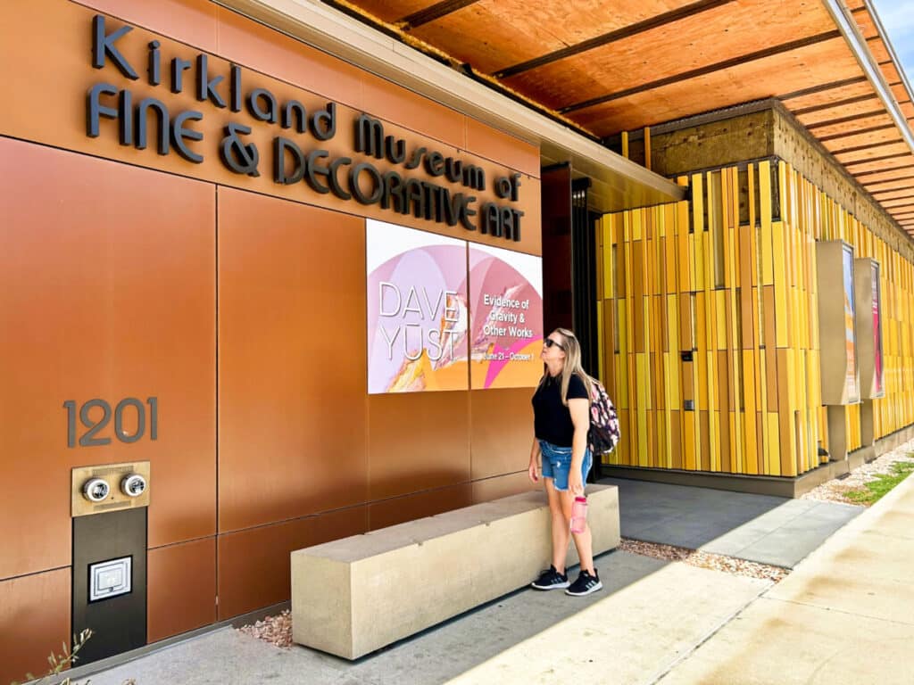 The author Laura Falin, looking at the outdoor signage of Kirkland Museum of Fine & Decorative Art