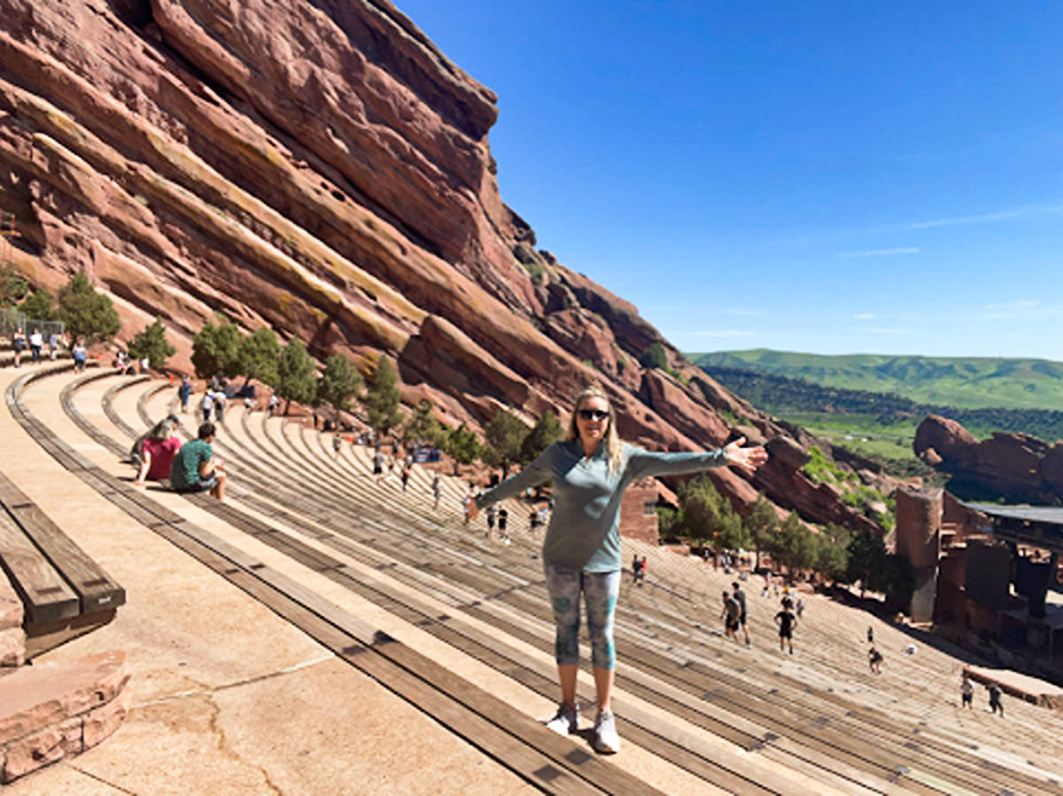 The author, Laura Falin, posing for a photo at the stairs of Red Rocks Amphitheater