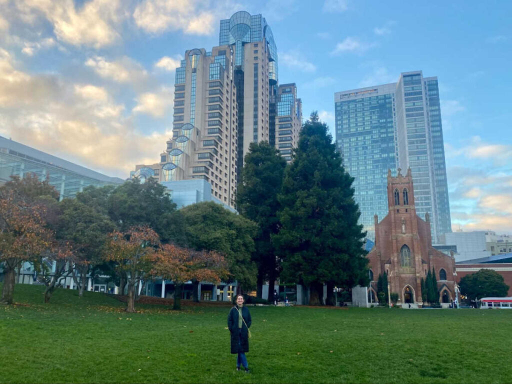 Travel Lemming writer Laura McFarland, posing for a photo at Yerba Buena Gardens with skyline views