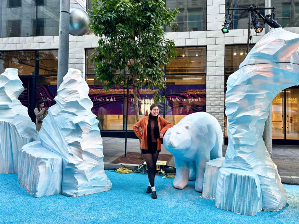 The author Laura posing for a photo with the sculptures at the Union Square Winter Walk