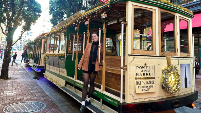 The author Laura, standing onboard a cable car with Christmas decorations